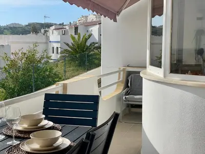 a balcony with a table and chairs and a window at RosaMar apartment sea view and pool in Albufeira