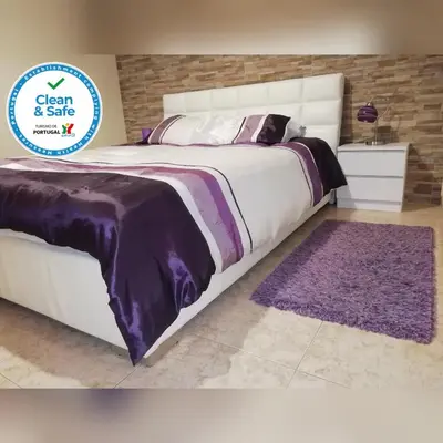 a bedroom with a large bed with a purple blanket at Apartamento Lara in Albufeira