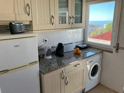 a kitchen with a washing machine and a window at KAP Sea View Balcony in Albufeira