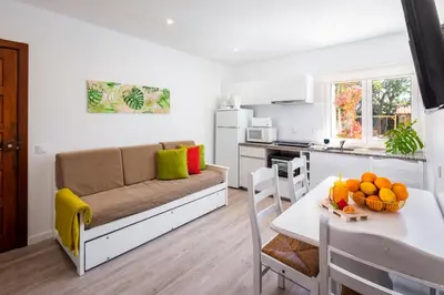 a living room with a couch and a table with fruit at Apartamentos Flor da Laranja, Albufeira by AlgarveBlossom in Albufeira
