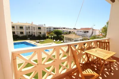 a balcony with a table and a swimming pool at Beauty by the Sea in Albufeira