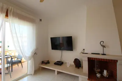 a living room with a fireplace and a tv on the wall at Beauty by the Sea in Albufeira