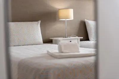 a bedroom with a bed with a table and a lamp at Carol & Vany in Quarteira