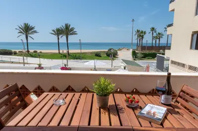 a wooden table on a balcony with a view of the beach at Carol & Vany in Quarteira