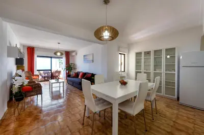 a kitchen and living room with a white table and chairs at Carol & Vany in Quarteira