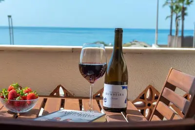 a bottle of wine and a bowl of strawberries on a table at Carol & Vany in Quarteira