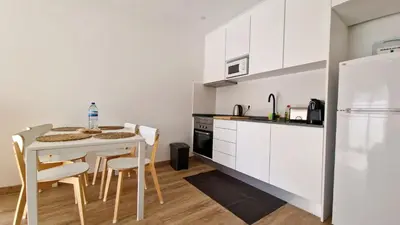 a kitchen with a table and chairs and a refrigerator at Apart JCMar - Near to the beach - WIFI - BY BEDZY in Albufeira