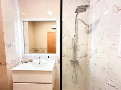 a bathroom with a sink and a shower with a mirror at Modern Ocean, Garden & Pool view Condo by BeCherish in Albufeira
