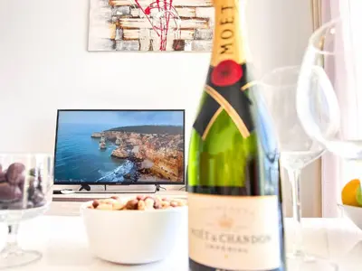 a bottle of wine sitting on a table with a bowl of food at Modern Ocean, Garden & Pool view Condo by BeCherish in Albufeira