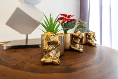 three gold figurines sitting on a wooden table at Casa beira mar Algarve in Albufeira