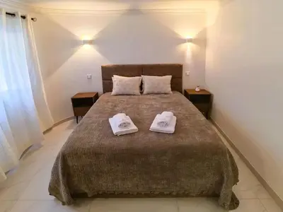 a bedroom with a large bed with two towels on it at Casa beira mar Algarve in Albufeira