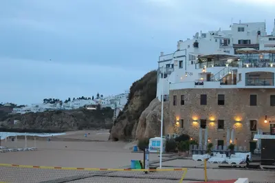a building on a beach next to a beach at Casa beira mar Algarve in Albufeira