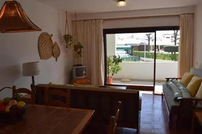 a living room with a couch and a table at Apartamento T2 com Piscina e Wifi a 350 metros da Praia in Roja- Pé