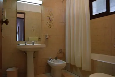 a bathroom with a sink and a toilet and a mirror at Apartamento T2 com Piscina e Wifi a 350 metros da Praia in Roja- Pé