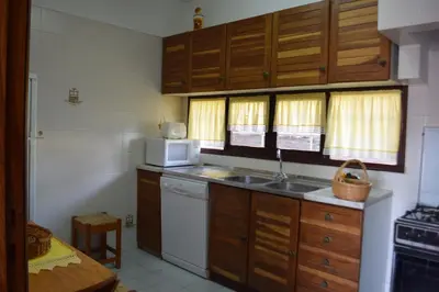 a kitchen with a sink and a microwave at Apartamento T2 com Piscina e Wifi a 350 metros da Praia in Roja- Pé