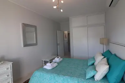 a bedroom with a bed with pillows and a mirror at APARTAMENTO MICÁ in Albufeira