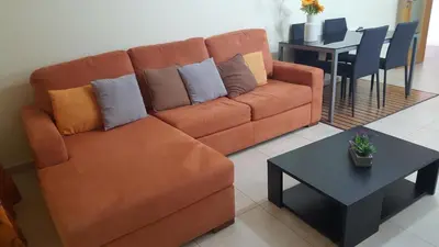 a brown couch in a living room with a table at Plaza 305 Albufeira in Albufeira