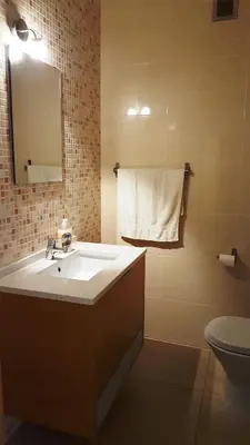 a bathroom with a sink and a toilet and a mirror at Plaza 305 Albufeira in Albufeira