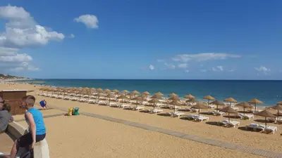 a group of beach chairs and umbrellas on a beach at Plaza 305 Albufeira in Albufeira