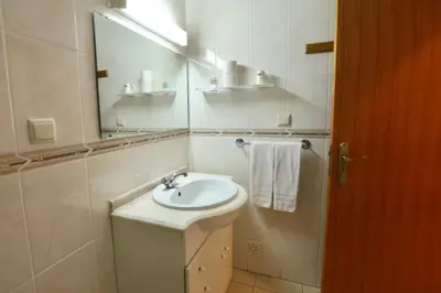 a white bathroom with a toilet and a sink at Rialgarve in Faro