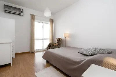a bedroom with a bed and a chair and a window at Casa Gago in Faro