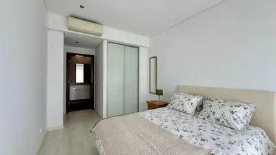 a white bedroom with a bed and a bathroom at Cavalo Prеto Holiday apartment 200m to the beach in Quarteira