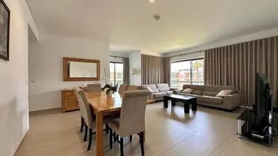 a living room with a table and a couch at Cavalo Prеto Holiday apartment 200m to the beach in Quarteira