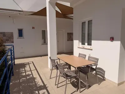 a bedroom with a bed and a desk with a laptop at Guest House Dianamar in Albufeira