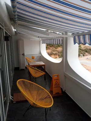 a room with two chairs and a table and two windows at Edifício Albufeira 406 in Albufeira