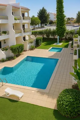 a swimming pool in front of a building at sol nascente in Vilamoura