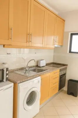 a kitchen with a washing machine and a sink at sol nascente in Vilamoura