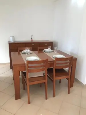 a wooden table and chairs with plates and wine glasses at sol nascente in Vilamoura