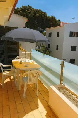 a patio with a table and chairs and an umbrella at sol nascente in Vilamoura