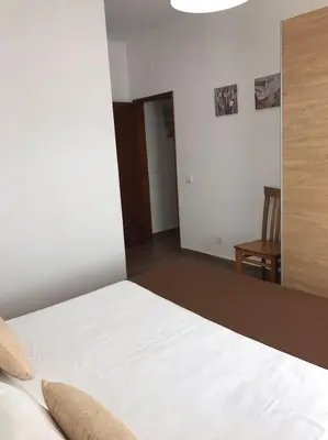 a bedroom with a white bed and a chair at Zesty Orange by ITHOUSE in Albufeira