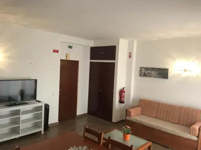 a living room with a couch and a television at Zesty Orange by ITHOUSE in Albufeira