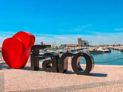 a red heart sitting on a bench next to a marina at AL - Comfortable House in Faro