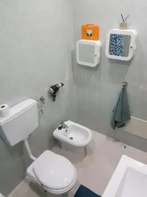 a white bathroom with a toilet and a sink at AL - Comfortable House in Faro