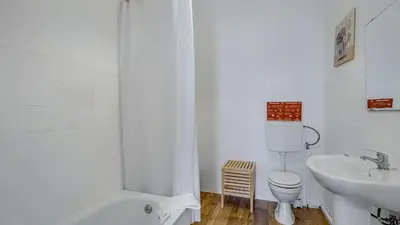 a white bathroom with a toilet and a sink at Hostel Casa d'Alagoa in Faro