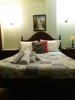 a bedroom with a bed with towels on it at Guest House Pacifica in Quarteira