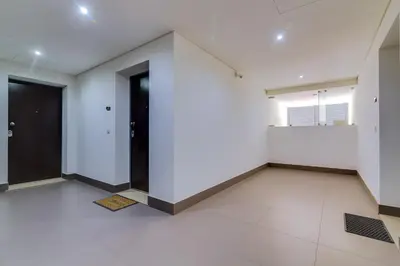 an empty room with white walls and a black door at Cavalo Preto Beach Resort in Quarteira