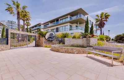 a house with a fence and a bench in front of it at Cavalo Preto Beach Resort in Quarteira