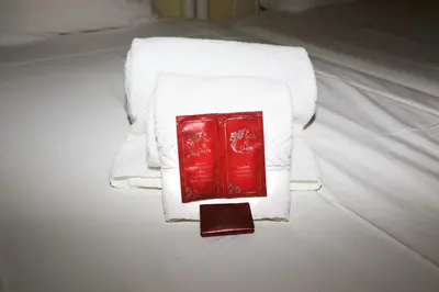a red book on a pile of towels on a bed at venha nadar a oura in Albufeira