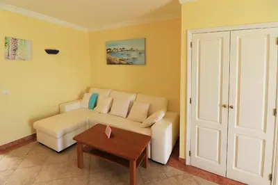 a living room with a couch and a table at venha nadar a oura in Albufeira