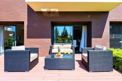 a patio with two wicker chairs and a table at L'Orangerie in Vilamoura
