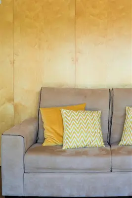 a couch with three yellow pillows on it at L'Orangerie in Vilamoura