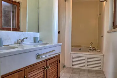 a bathroom with two sinks and a tub with a mirror at Casa da Palmeira, pool & soccer pitch in Vilamoura