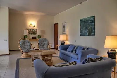 a living room with blue couches and chairs at Casa da Palmeira, pool & soccer pitch in Vilamoura
