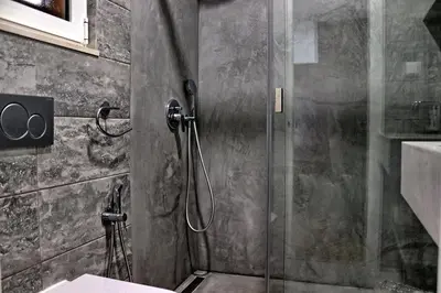 a shower with a glass door in a bathroom at Casa da Palmeira, pool & soccer pitch in Vilamoura