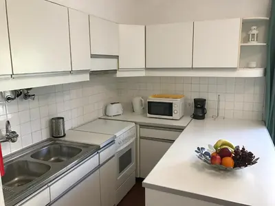 a kitchen with white cabinets and a bowl of fruit on a counter at BREEZY NEST by ITHOUSE in Albufeira