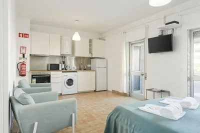 a living room with two tables and a kitchen at Sea Studio in Quarteira
